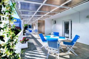 a patio with a table and blue chairs on it at Bayview Apartments in Tivat