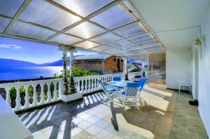 a patio with a table and chairs and the ocean at Bayview Apartments in Tivat
