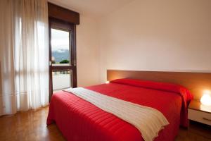 a bedroom with a red bed and a window at Casa Lucia in Nago-Torbole