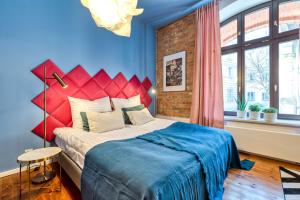 ポズナンにあるRetro Apartament Butikowy Stary Rynekのベッドルーム1室(赤いヘッドボード付きの大型ベッド1台付)