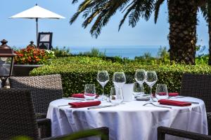 una mesa con copas de vino en ella con el océano en el fondo en Hôtel La Réserve, en San Juan de Luz