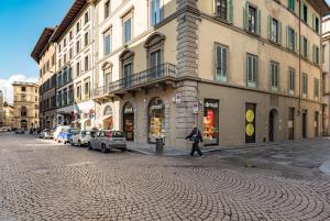 a person walking down a street next to buildings at Design Apartments Florence- Florence City Center in Florence