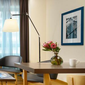 
a table topped with a vase filled with flowers at UNAHOTELS Century Milano in Milan
