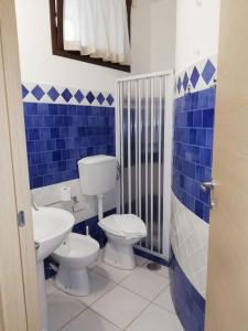un bagno bianco e blu con servizi igienici e lavandino di B&B Cesaranum a Casarano