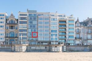 a large building with a red sign in front of it at Ter Duinen in Ostend