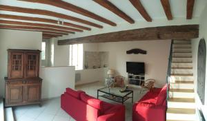 a living room with red couches and a staircase at Les Marronniers in Baron