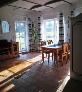 cocina con mesa y sillas en una habitación en Pottkiekerhus en Luhnstedt