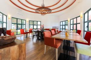 uma sala de jantar com mesas, cadeiras e janelas em Sintra Rural Home - Cerrado da Serra em Sintra