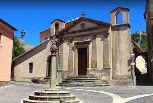una iglesia con una cruz frente a un edificio en Casa Vacanze “Dream House” en Scano Montiferro