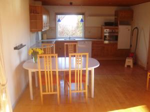 a kitchen with a table and chairs and a kitchen with a window at "Alléhuset" in Roslev