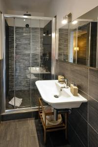 ein Badezimmer mit einem weißen Waschbecken und einer Dusche in der Unterkunft Domus Castroni Pompeo Magno in Rom