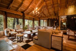 a living room with a couch and a table at Huilo Huilo Nawelpi Lodge in Huilo Huilo