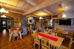 a restaurant with tables and chairs and a flat screen tv at Zakopiański Dwór in Zakopane