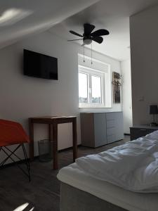1 dormitorio con 1 cama y ventilador de techo en ANJA'S motel, en Bruchmühlbach-Miesau