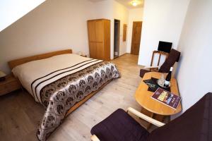 a bedroom with a bed and a wooden table at Hotel Pod Zámkem in Vranov nad Dyjí