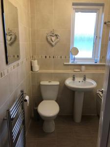 Un baño con inodoro, lavabo y ventana. en 12 Lochiel Road, en Fort William