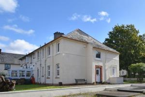um edifício branco com um banco à frente em 12 Lochiel Road em Fort William