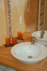 een badkamer met een witte wastafel en een spiegel bij Chambres d'Hôtes Les Coquelicots in Francueil