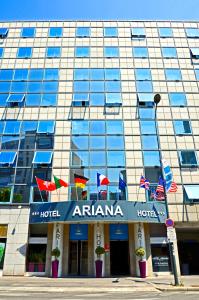 um hotel com bandeiras em frente a um edifício em Hotel Gratte-Ciel Ariana em Villeurbanne
