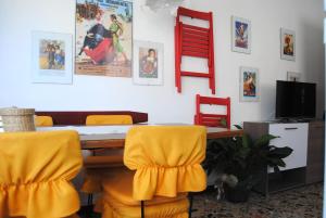 ein Esszimmer mit einem Tisch und gelben Stühlen in der Unterkunft Bnbook Garden View Villa in Sesto Calende
