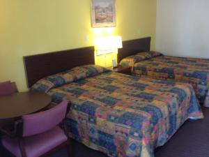 Habitación de hotel con 2 camas y mesa en Guest Inn Lebanon (Ohio), en Lebanon