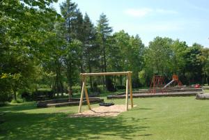 a park with a swing set in the grass at Banbury Hill Farm in Charlbury