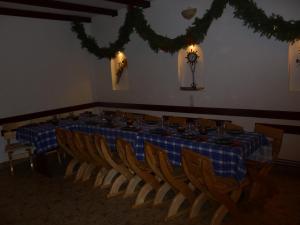 a long table with chairs and a blue plaid table cloth at Pensiunea Belvedere in Bran