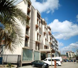 a tall building with cars parked in front of it at Marcen Addis Hotel in Addis Ababa