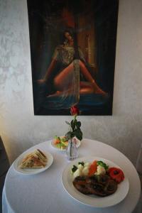 a table with two plates of food and a painting at Marcen Addis Hotel in Addis Ababa