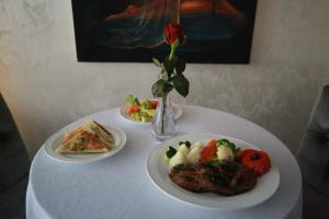 亞的斯亞貝巴的住宿－Marcen Addis Hotel，一张桌子,上面有两盘食物和玫瑰花瓶