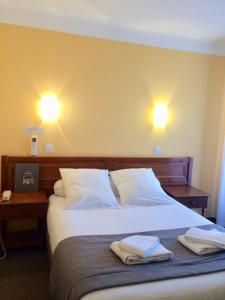 Een bed of bedden in een kamer bij Hotel des Arcades