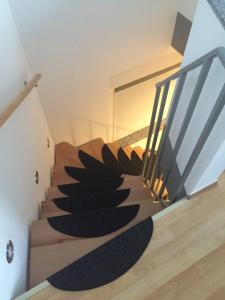 eine Wendeltreppe in einem Haus mit schwarzem Teppich in der Unterkunft Apartment mit Parkblick in Tönisvorst
