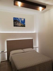 a bedroom with a bed and a picture on the wall at Masseria Nzeta in Carovigno