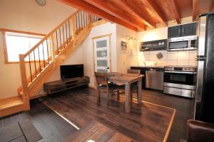 a kitchen with a dining room table and a staircase at Red Cariboo Apartments in Anahim Lake