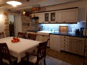 una cocina con una mesa con un bol de fruta. en Guesthouse Juric en Skradin