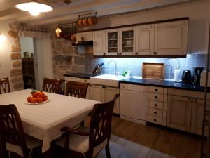 a kitchen with a table with a bowl of fruit on it at Guesthouse Juric in Skradin