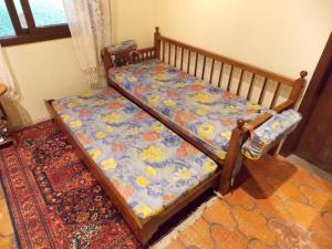a wooden bed in a room with a rug at Chalé no Centro de Canela in Canela