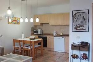 a kitchen with a table and a kitchen with a dining room at Islote House in Famara