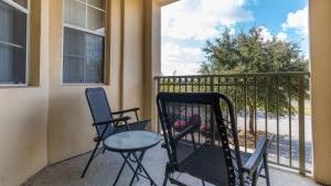 a balcony with two chairs and a table on a balcony at Disney's Den - Closer to all the fun! in Davenport +6 photos