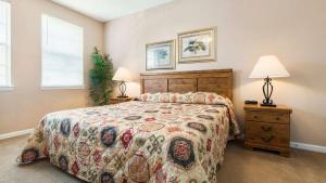 a bedroom with a large bed and two lamps at Disney's Den - Closer to all the fun! in Davenport