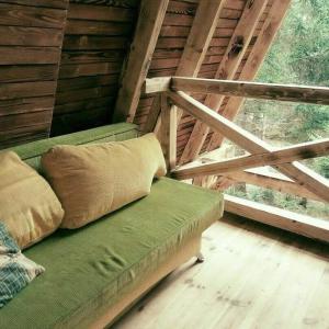 um sofá verde num quarto com uma janela em Ski Lake Cottage Krpáčovo em Krpacovo