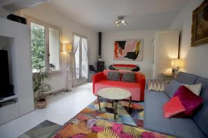 sala de estar con sofá rojo y mesa en Jolie maison avec jardin clos - Fontainebleau Héricy, 40 min Paris, en Héricy