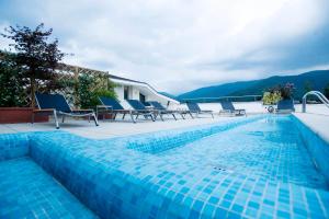 a swimming pool with blue chairs next to a house at Regal Residence in Brescia