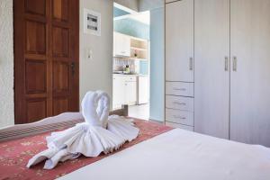 a white swan decoration sitting on top of a bed at Irilena Studios and Apartments in Lassi