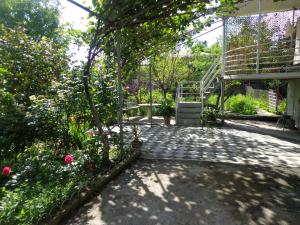 a garden with a staircase and some flowers and trees at At Nana's in Lagodekhi