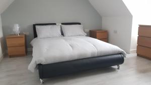 a bedroom with a large bed with two night stands at Vineyard Vale Cottage in Saundersfoot +12 photos