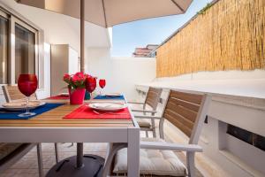 - une table avec des chaises et un parasol sur le balcon dans l'établissement Exquisite Retreat in a Traditional Area of Porto, à Porto