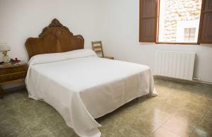 1 dormitorio con 1 cama blanca grande y cabecero de madera en Hiker's TownHouse, en Sóller