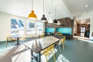 a dining room with tables and chairs and windows at Nowhere Special in Rossland