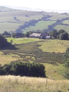 um campo aberto com uma quinta à distância em The Barn Annexe, Cefn-Yr-Allt em Crickadarn